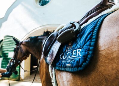 Detailaufnahme einer Pferdedecke und eines Sattels im Stall des Reitsportzentrumns auf Gut Ising am Chiemsee.