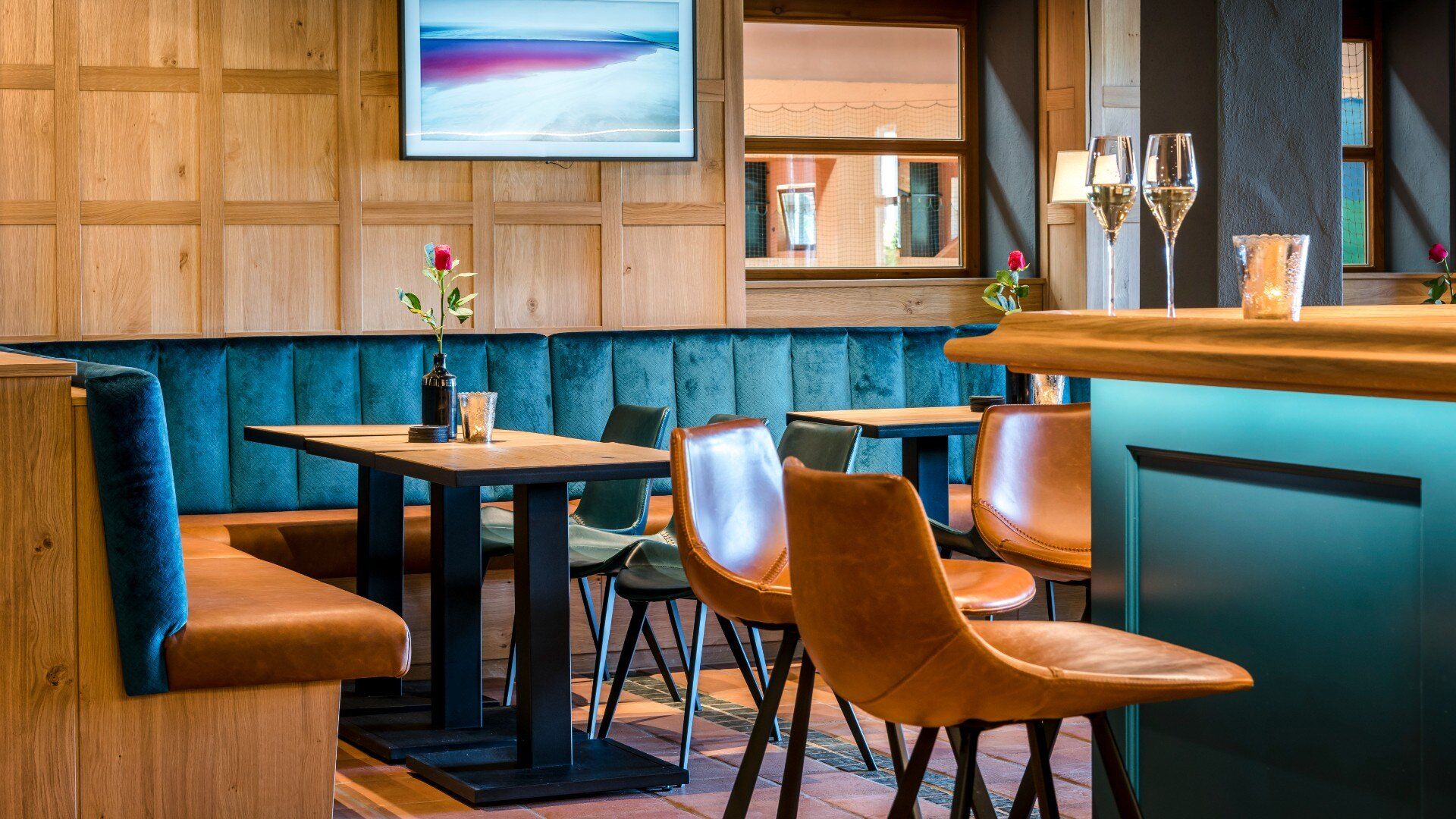 Blick auf eine Sitzbank mit blauem Samtstoff und brauner Lederpolsterung im Restaurant des Hotels am Chiemsee